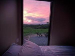 1 dormitorio con vistas a una cama con ventana en Little Jogo, 