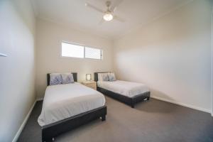 1 Schlafzimmer mit 2 Betten und einem Fenster in der Unterkunft Gold Coast Theme Park4BD Family with Big Pool in Pimpama