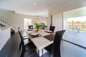 eine Küche und ein Esszimmer mit einem Tisch und Stühlen in der Unterkunft Gold Coast Theme Park4BD Family with Big Pool in Pimpama
