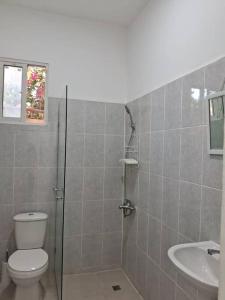 uma casa de banho com um chuveiro, um WC e um lavatório. em Casa Zanelli, lugar de paz… em Baní