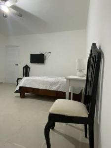 1 dormitorio con 1 cama, 1 mesa y 1 silla en Casa Zanelli, lugar de paz… en Baní