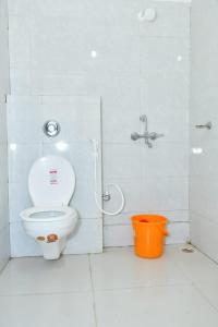 La salle de bains est pourvue de toilettes, d'une douche et d'un seau. dans l'établissement DESIRE LODGE, à Dālkola