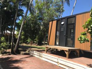 a tiny house with a bench on a sidewalk at Cardwell by the Sea in Cardwell