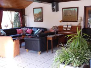 uma sala de estar com sofás e um piano em Atmospheric holiday home in Durbuy with sauna em Septon