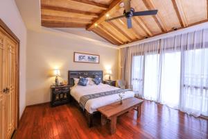 1 dormitorio con 1 cama y suelo de madera en Yangshuo Tea Cozy, en Yangshuo