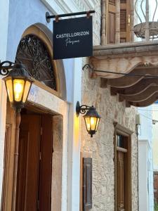邁伊斯蒂的住宿－Castellorizon Pensione，建筑物一侧有两盏灯的标志