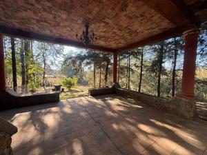 a large screened in porch with trees in the background at Cabaña El Tigrito in Quiroga