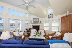 uma sala de estar com um sofá azul e cadeiras em The Nest at Deep Cove em Chester