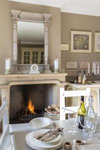 a dining table with a fireplace in a kitchen at Roundhill Farmhouse in Bath