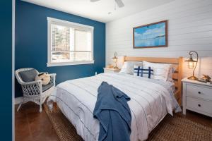 um quarto com paredes azuis e uma cama e uma cadeira em The Nest at Deep Cove em Chester