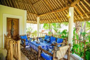 a patio with a table and chairs on a porch at 3 Bed Villa Sleeps 6 - Pool Garden Chef Option in Diani Beach