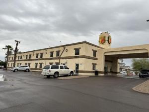 ein großes Gebäude mit Autos auf einem Parkplatz in der Unterkunft Super 8 by Wyndham Casa Grande in Casa Grande