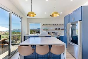eine Küche mit blauen Schränken und eine Kücheninsel mit Stühlen in der Unterkunft Lakeside Luxury - Sams Beachcomber Lake Access in Lake Havasu City