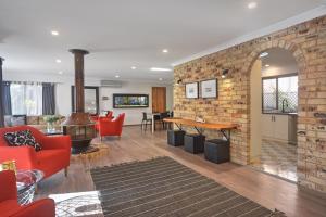 an open living room with a brick wall at Pleasant Way River Lodge in Nowra
