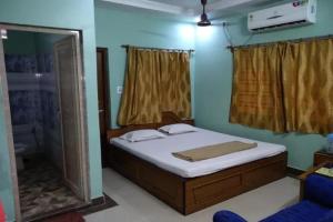 a bedroom with a bed and a mirror at Hotel Sunny New Digha Near Sea Beach View Point - Couple Friendly in Digha