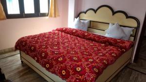 a bedroom with a bed with a red comforter at Hotel Sunny New Digha Near Sea Beach View Point - Couple Friendly in Digha