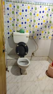 a bathroom with a toilet with a black seat at Hotel Sunny New Digha Near Sea Beach View Point - Couple Friendly in Digha