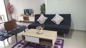 uma sala de estar com um sofá preto e uma mesa em Vila Adinda Syariah C-4 Bukit Gardenia Resort em Garut