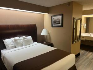 a hotel room with a large bed and a bathroom at Americas Best Value Inn Kalispell in Kalispell