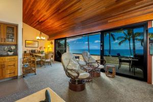 a living room with chairs and a view of the ocean at MAKENA SURF, #E-303 condo in Wailea