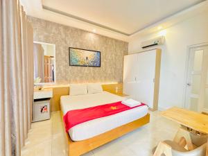 ein kleines Schlafzimmer mit einem Bett und einem Tisch in der Unterkunft Lộc Thiên Ân hotel in Biên Hòa