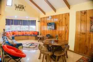 sala de estar con mesa y sofá en Cozy Baguio House - Outlook Drive (DOT accredited) en Baguio