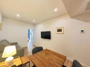 a living room with a table and a television at Yellow Apartment in Puerto del Rosario in Puerto del Rosario