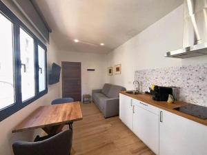 eine Küche und ein Wohnzimmer mit einem Tisch und einem Sofa in der Unterkunft Blue Apartment in Puerto del Rosario in Puerto del Rosario