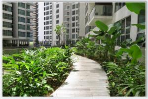a walkway in a city with plants and buildings at Regalia Suite Studio in Kuala Lumpur