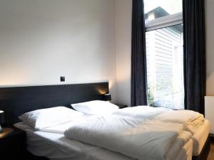 1 dormitorio con 1 cama grande y ventana grande en Modern holiday home with decorative fireplace near Veluwe en Hoenderloo