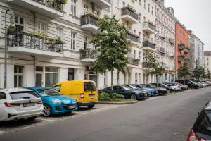 una fila di auto parcheggiate di fronte agli edifici di Spacious 3BR plus AC Self Check-in Street Parking a Berlino