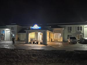 a man standing in front of a hotel at night at Americas Best Value Inn Kalispell in Kalispell