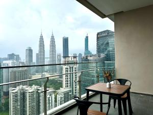 uma varanda com mesa e cadeiras e vista para a cidade em The Manor, KLCC em Kuala Lumpur