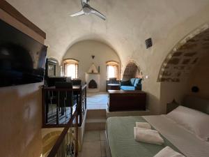 a living room with a bed and a couch at MONOVASIA SUITES Tholos Hammam in Monemvasia +23 photos