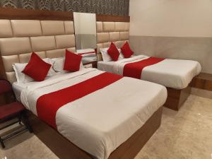 Cette chambre d'hôtel comprend 2 lits avec des oreillers rouges. dans l'établissement Hotel Dream Palace Residency - Near US Consulate, BKC LBS Marg, à Mumbai