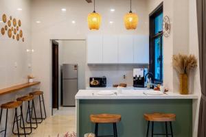 a kitchen with a green island in a kitchen with stools at Bungalow Putrajaya 15pax w Private Pool Gathering in Putrajaya