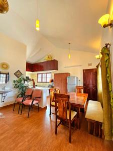 cocina y comedor con mesa de madera y sillas en Lakshmi Illam Guesthouse for Families only en Kodaikānāl