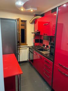 a kitchen with red cabinets and a red counter top at Apartament YariSen in Craiova