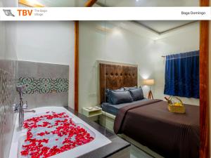 um quarto com uma cama e uma banheira cheia de rosas vermelhas em Beach Doorz Place-TBV em Baga