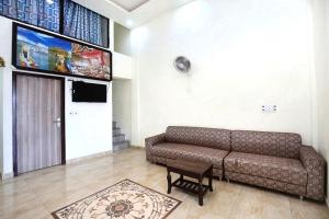 uma sala de estar com um sofá e uma televisão em ANGAD RESIDENCY em Amritsar
