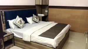 - une chambre avec un grand lit et des oreillers dans l'établissement ANGAD RESIDENCY, à Amritsar