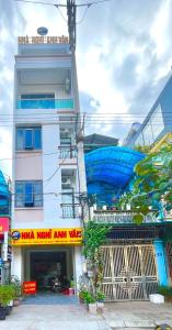 a tall white building with a blue object on it at NHÀ NGHỈ ANH VĂN in Dồng Văn