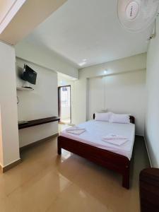 ein Schlafzimmer mit einem großen Bett in einem Zimmer in der Unterkunft HOTEL CHRUCH SIDE in Madikeri