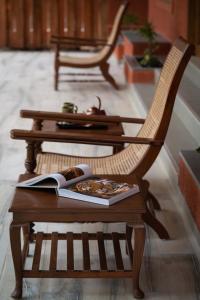 una silla de madera y una mesa con un libro. en SAJ IN THE FOREST - PENCH, en Seonī