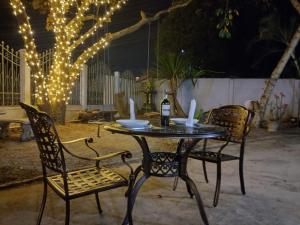 a table with two chairs and a bottle of wine at Sipanya Guesthouse in Muang Phônsavan
