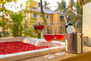 a table with two glasses of wine and a tray of cherries at Adamo The Bellus Calangute in Calangute