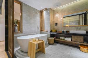 y baño con bañera y lavamanos. en Xisu Garden Inn Lijiang, en Lijiang