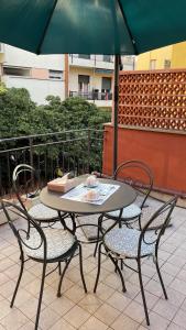 a table and chairs with an umbrella on a patio at Casa Di Emma (camera Ponente) in Sestri Levante
