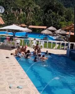 un grupo de personas en la piscina de un complejo en Cabaña del lago, en Cocorná