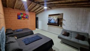a room with two couches and a tv on a wall at Cabaña del lago in Cocorná